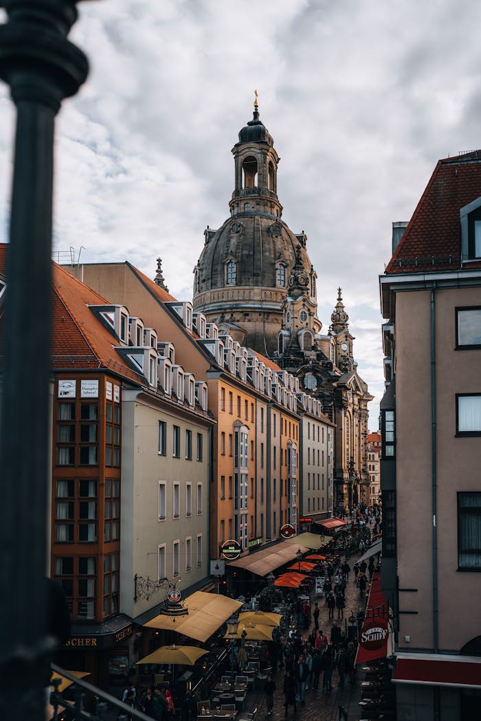 A vibrant street scene in Dresden with the iconic Frauenkirche and bustling pedestrians.