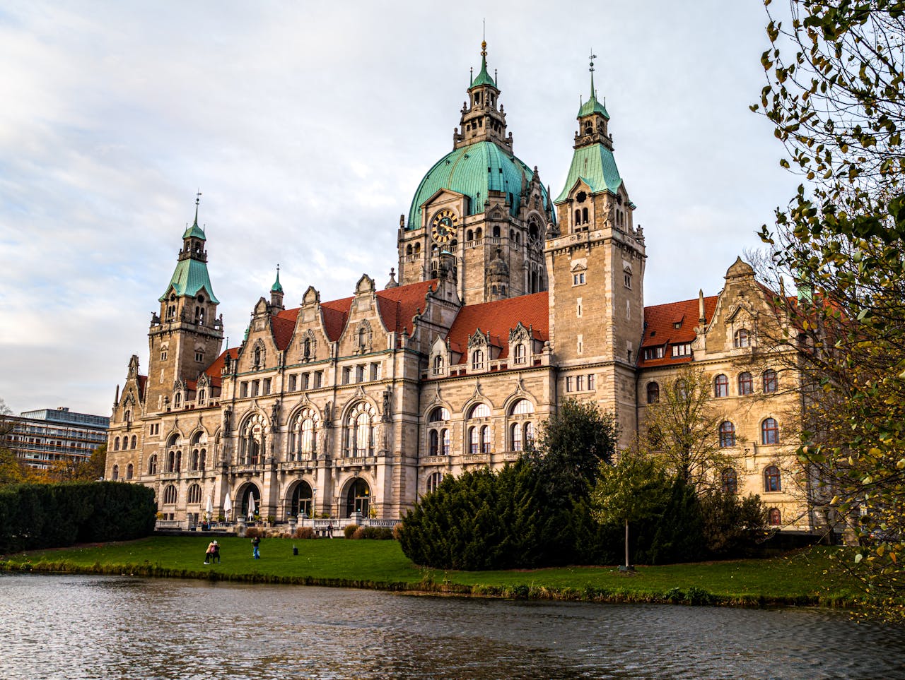 Beautiful photograph capturing the historic New Town Hall in Hanover, Germany with scenic surroundings.