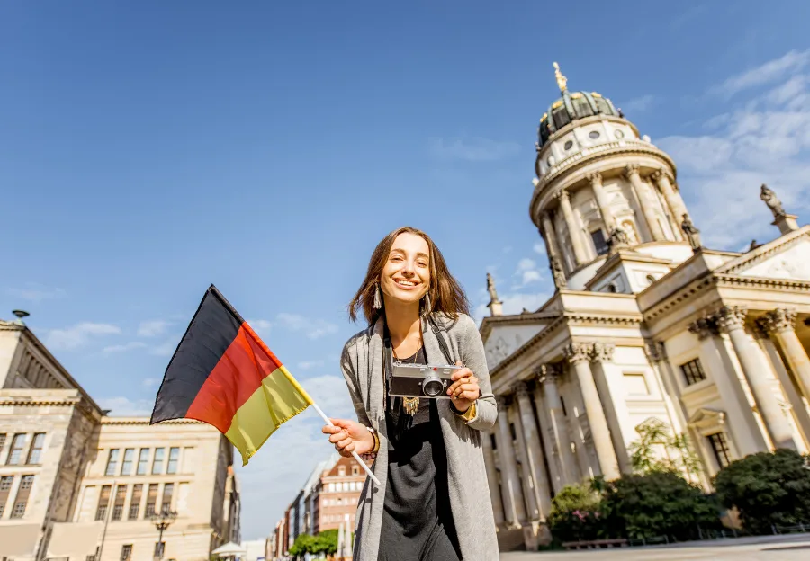 ours-journey The iconic Reichstag building in Berlin with a German flag against a blue sky, symbolizing democracy.